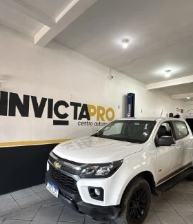 Picape Mitsubishi branca na oficina